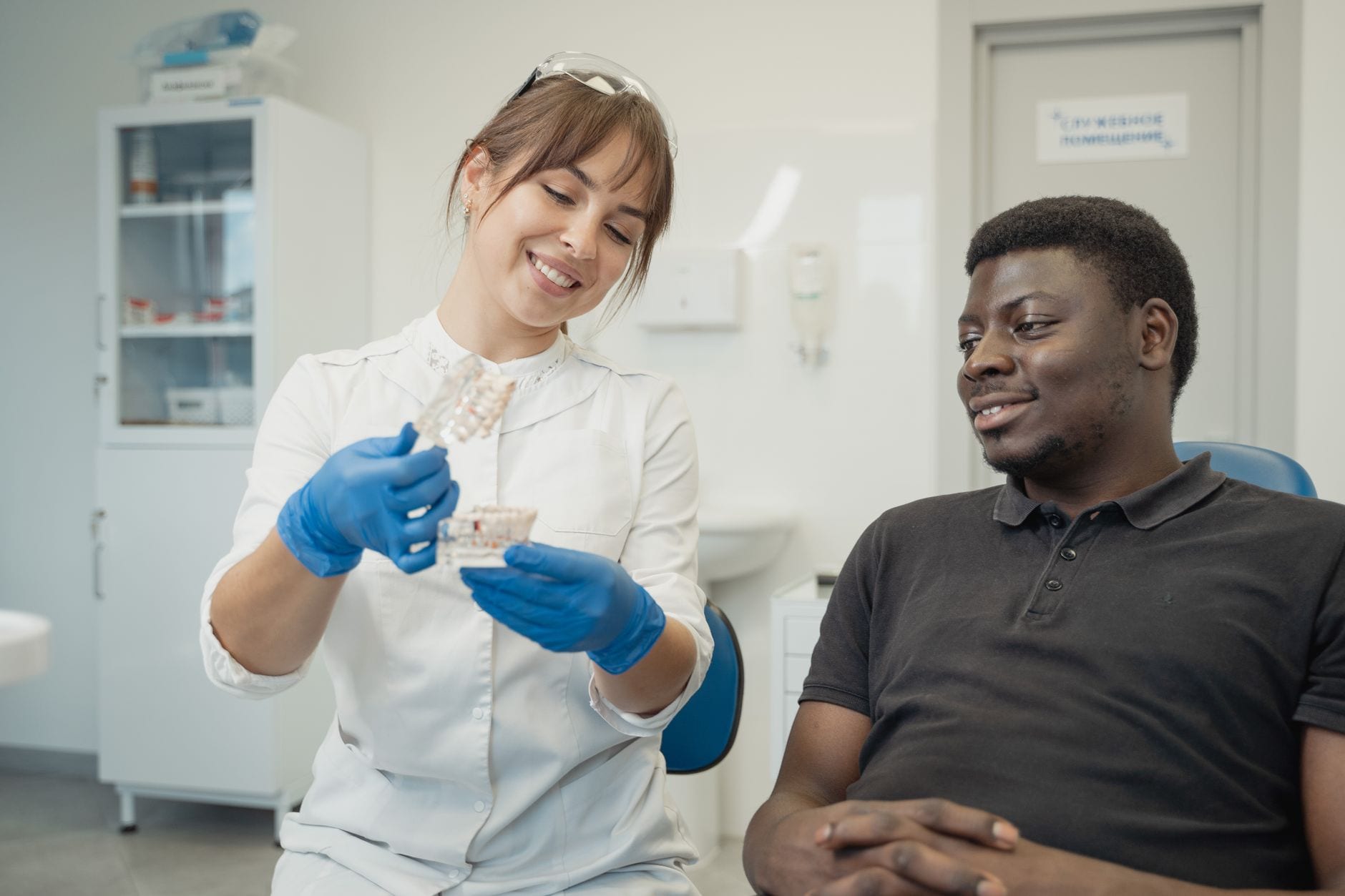 A dentist chatting with a smiling patient in a modern clinic